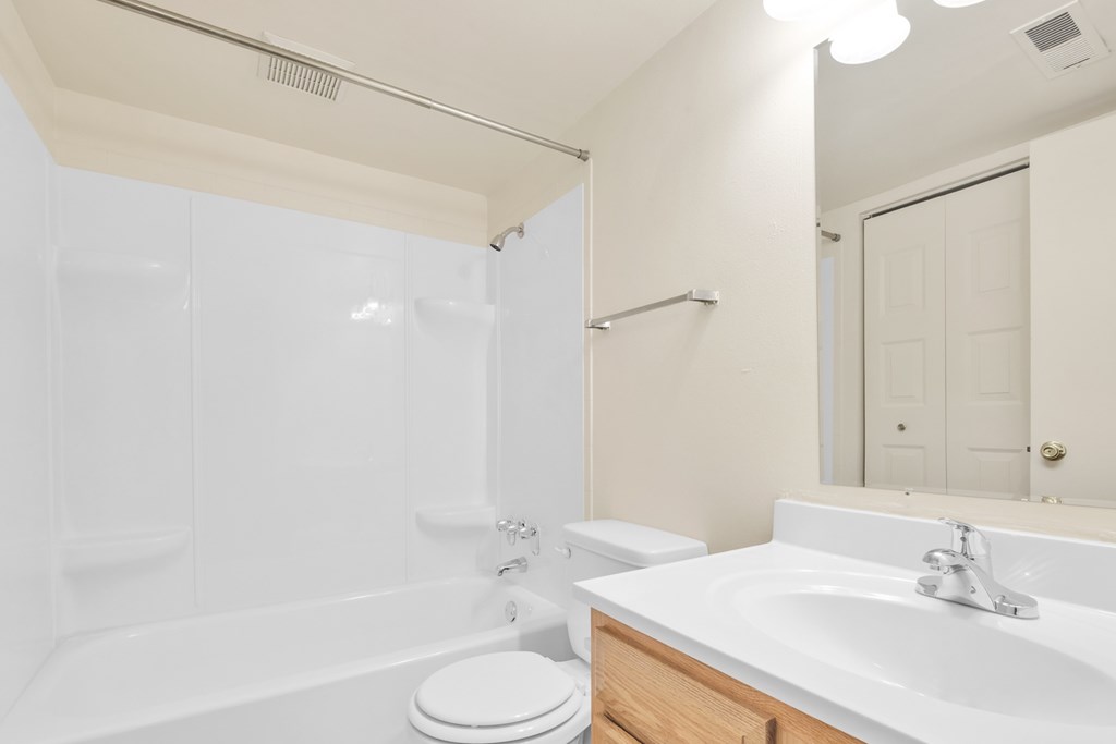 A white bathroom with a toilet, sink, and bathtub.