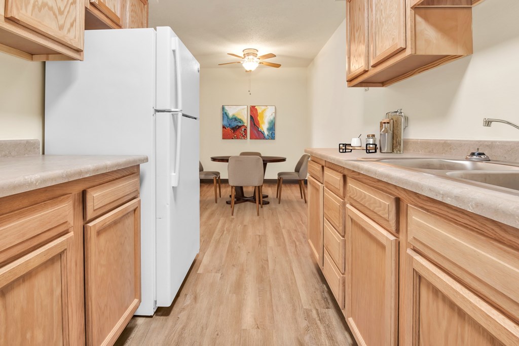 A kitchen with wooden cabinets and a white refrigerator.