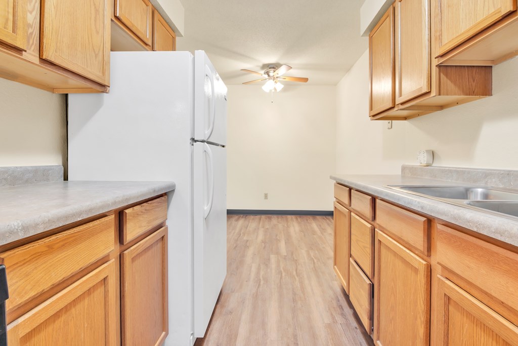 A kitchen with wooden cabinets and a white refrigerator.