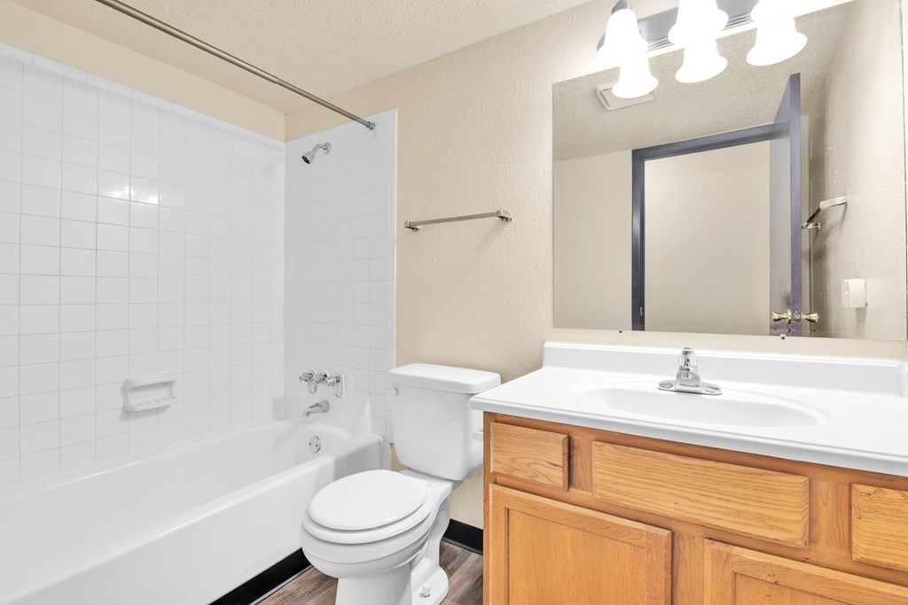 A white toilet sits next to a white sink in a bathroom.