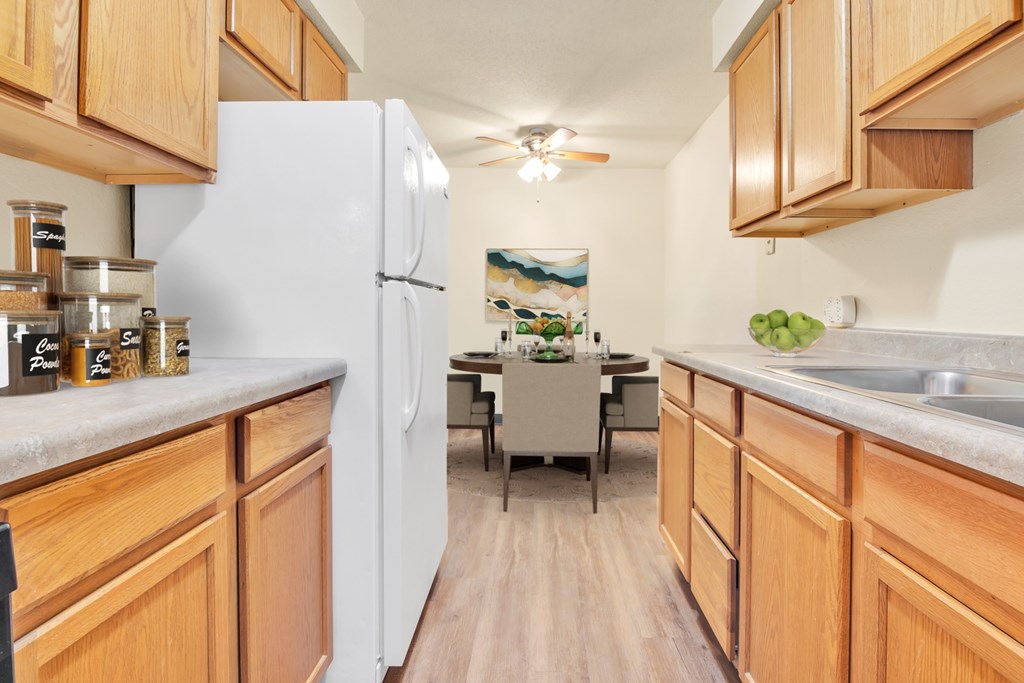 A kitchen with wooden cabinets and a white refrigerator.
