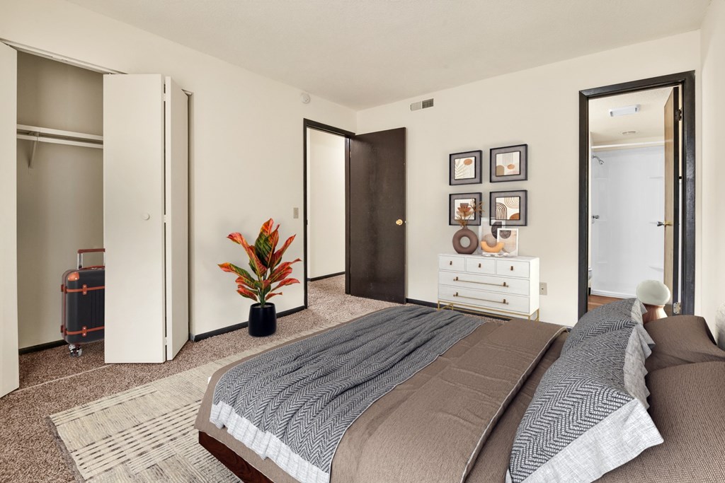 A bedroom with two beds and a plant.