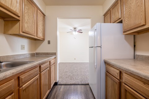 A kitchen with wooden cabinets and a white refrigerator.