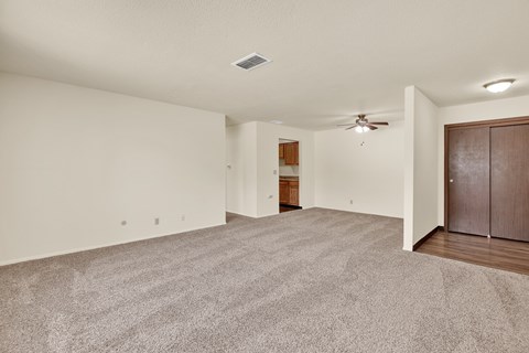 A spacious room with a ceiling fan and carpeted floor. at Kimberly Club Apartments, Davenport, 52807