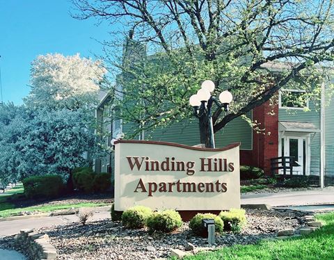 a sign in front of a winding hills apartments building