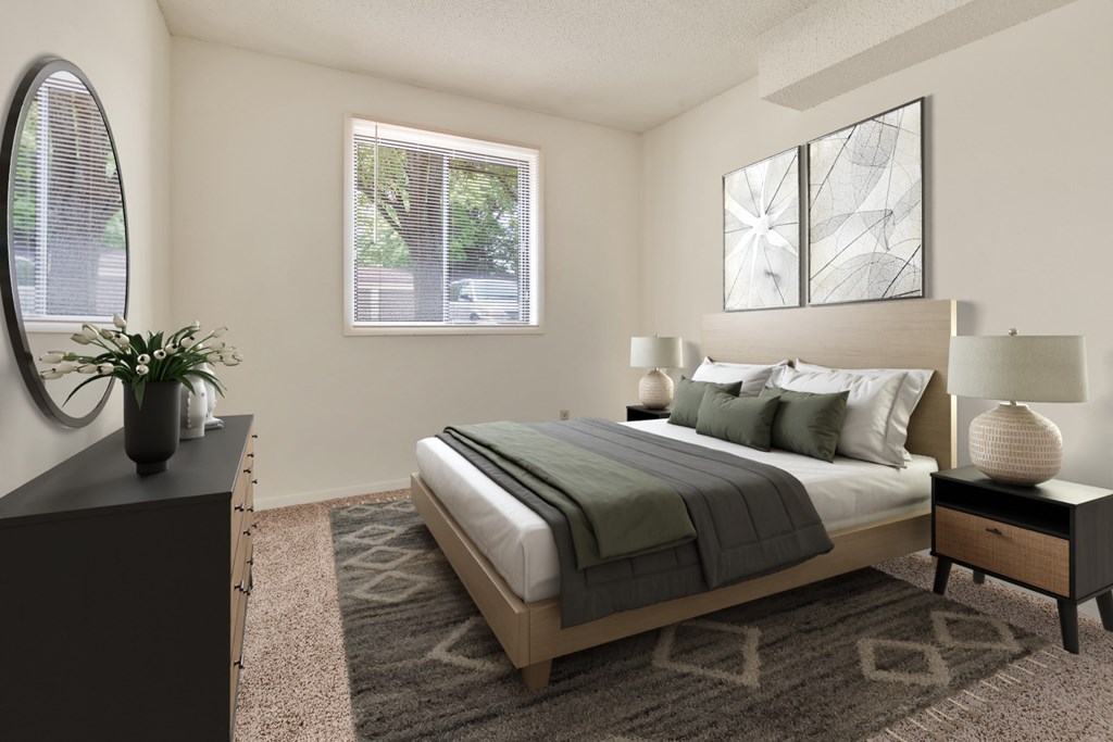 A bedroom with a large bed, a nightstand, and a mirror.