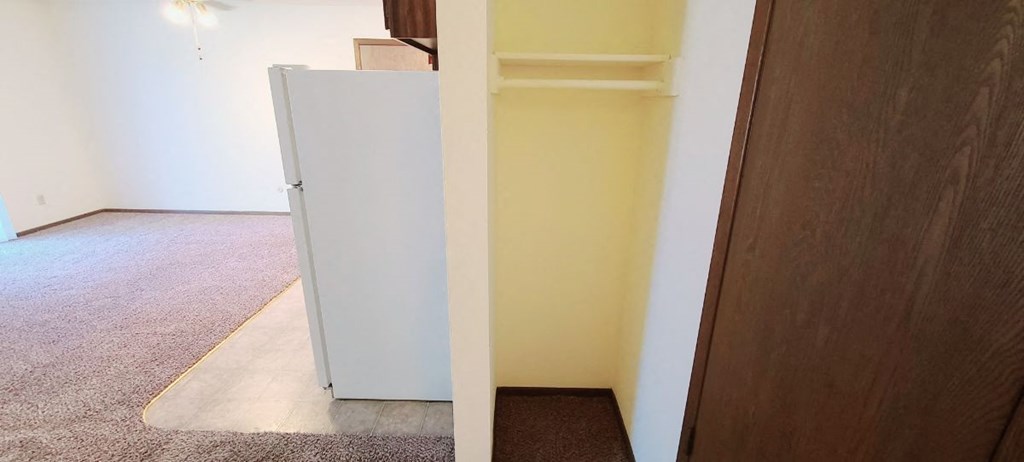 a white refrigerator in the corner of a room