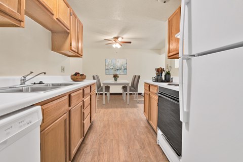 A kitchen with wooden cabinets and a white fridge.
