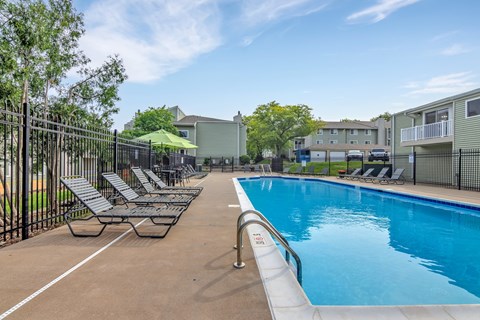 A pool with a slide and sun loungers.