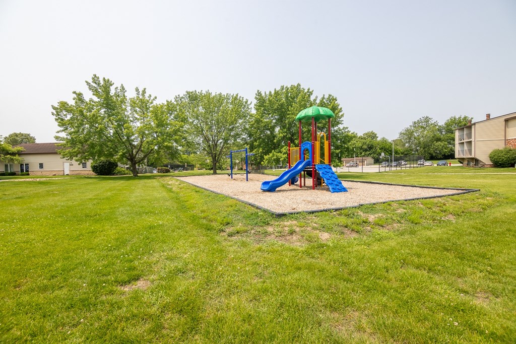 A playground with a green and blue slide.
