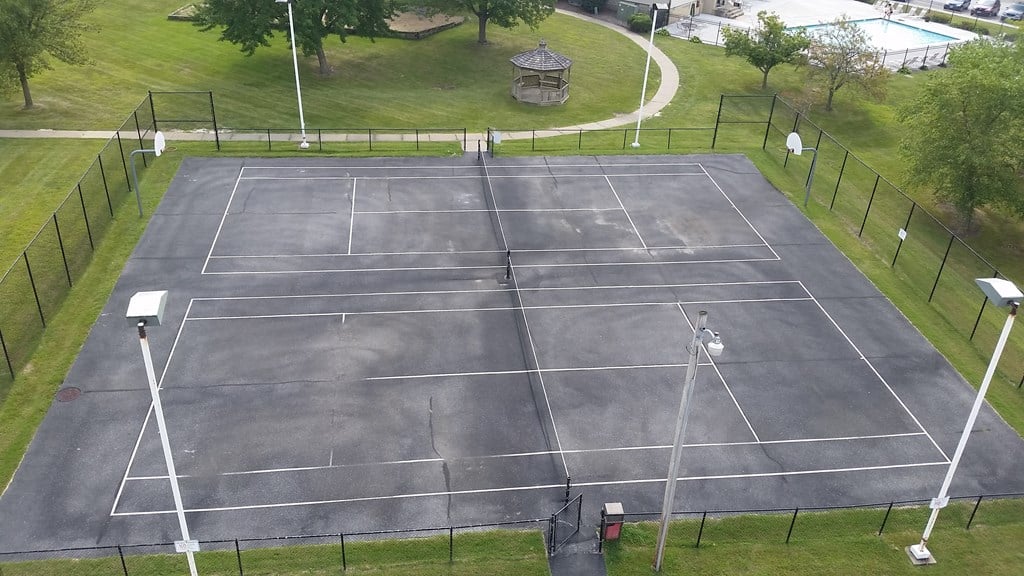 A tennis court surrounded by a black fence.