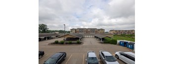 A parking lot with cars and a building in the background.