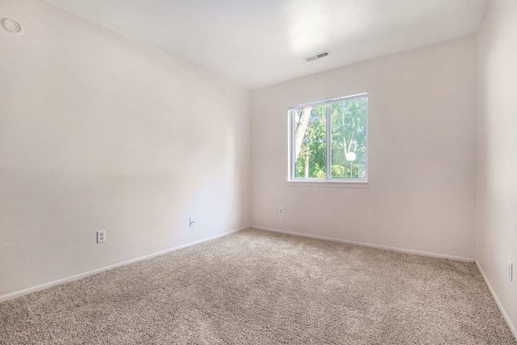 an empty room with carpet and a window