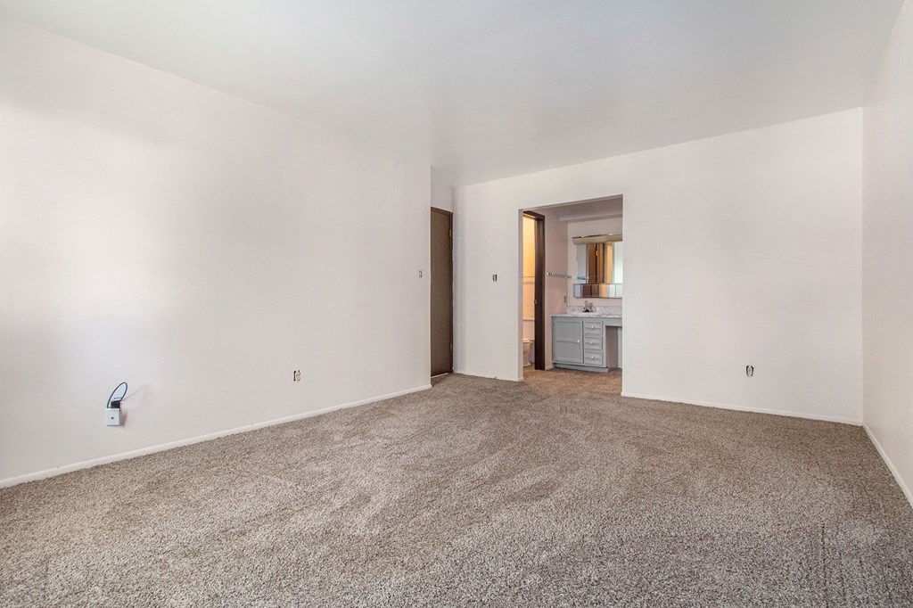 an empty living room with carpet and white walls