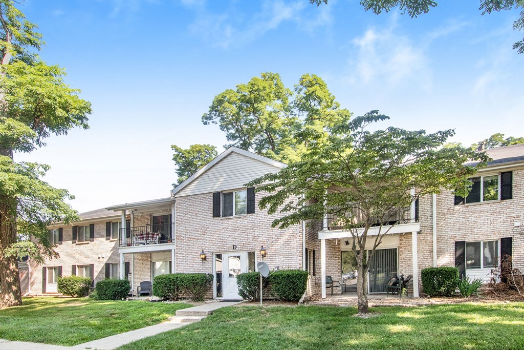 the view of an apartment building with green grass and trees