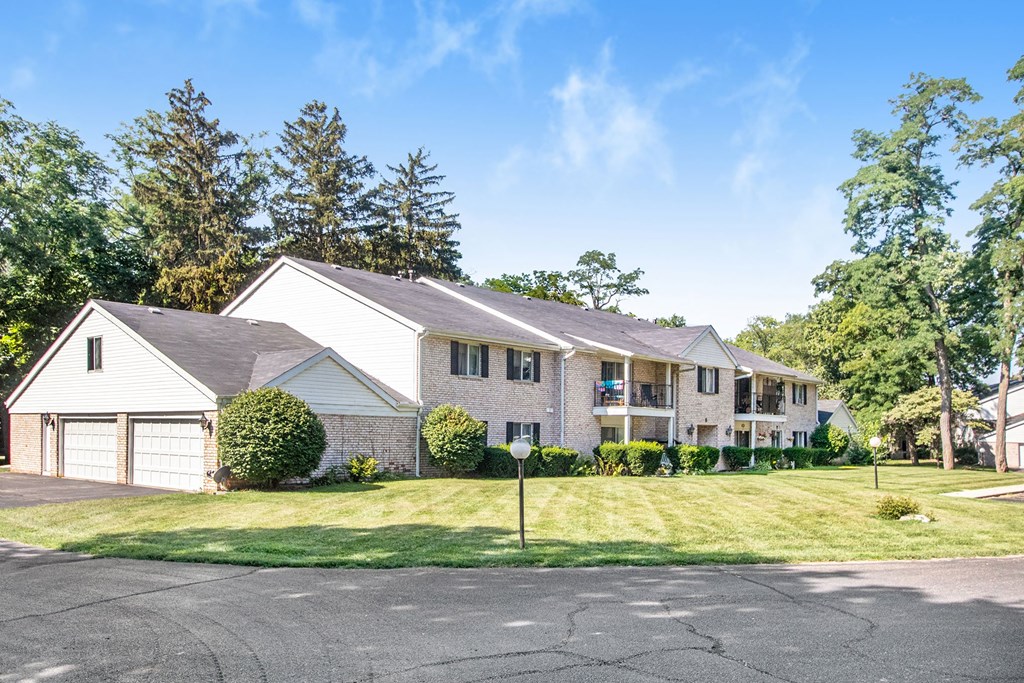 a white and gray house with a lawn and trees
