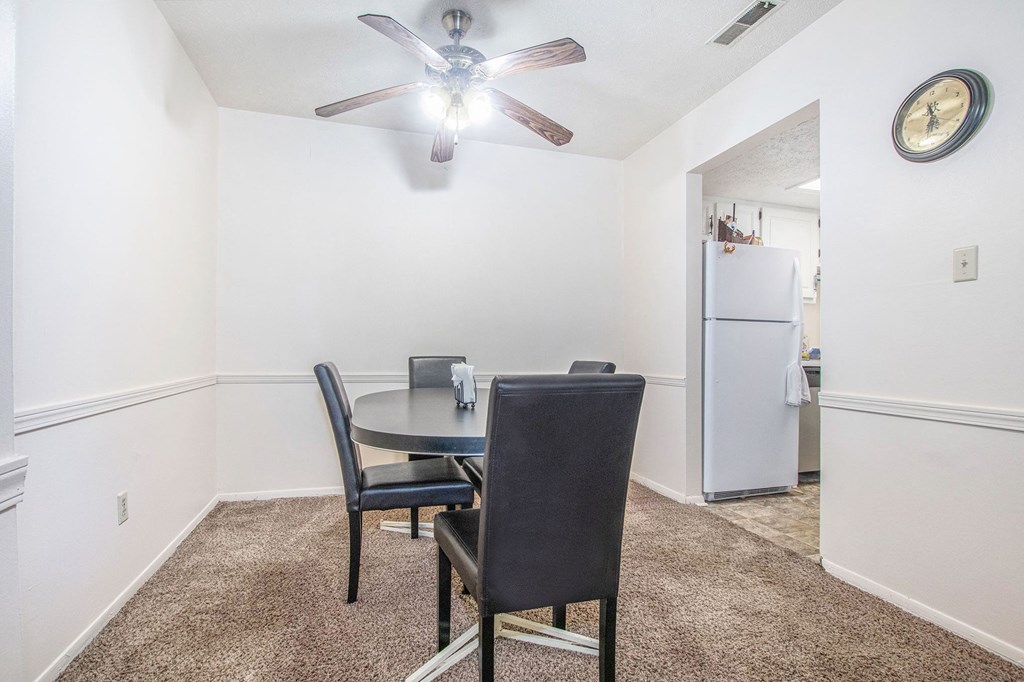 a dining room with a table and chairs and a ceiling fan