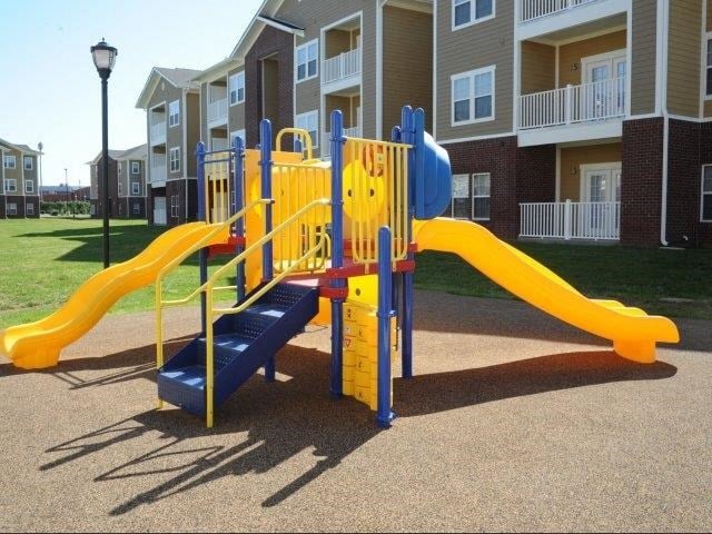 a playground with a blue and yellow slide