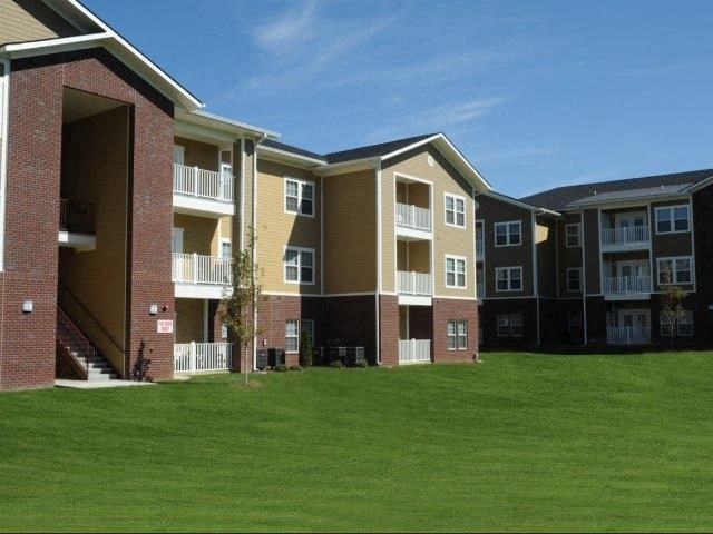 an apartment building with green grass in front of it