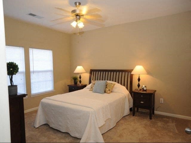 a bedroom with a bed and a ceiling fan