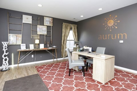 A room with a desk and a chair in front of a wall with a sun design on it.