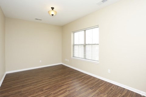 A room with a window and wooden flooring.