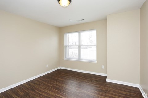 A room with a window and wooden floors.