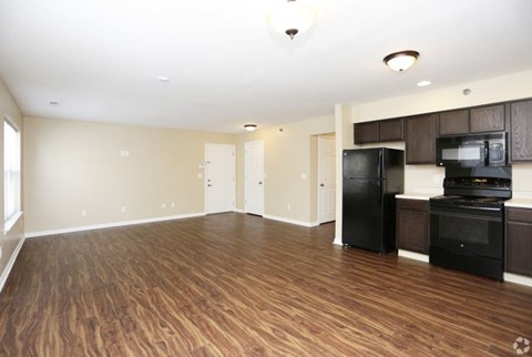 A kitchen area with a black fridge and microwave.