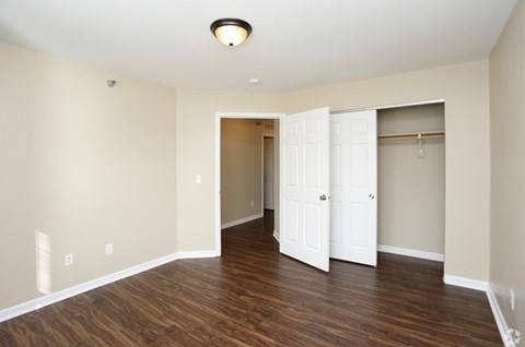 A room with a white door and a brown floor.