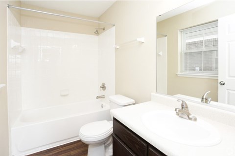 A white toilet sits next to a white sink in a bathroom.
