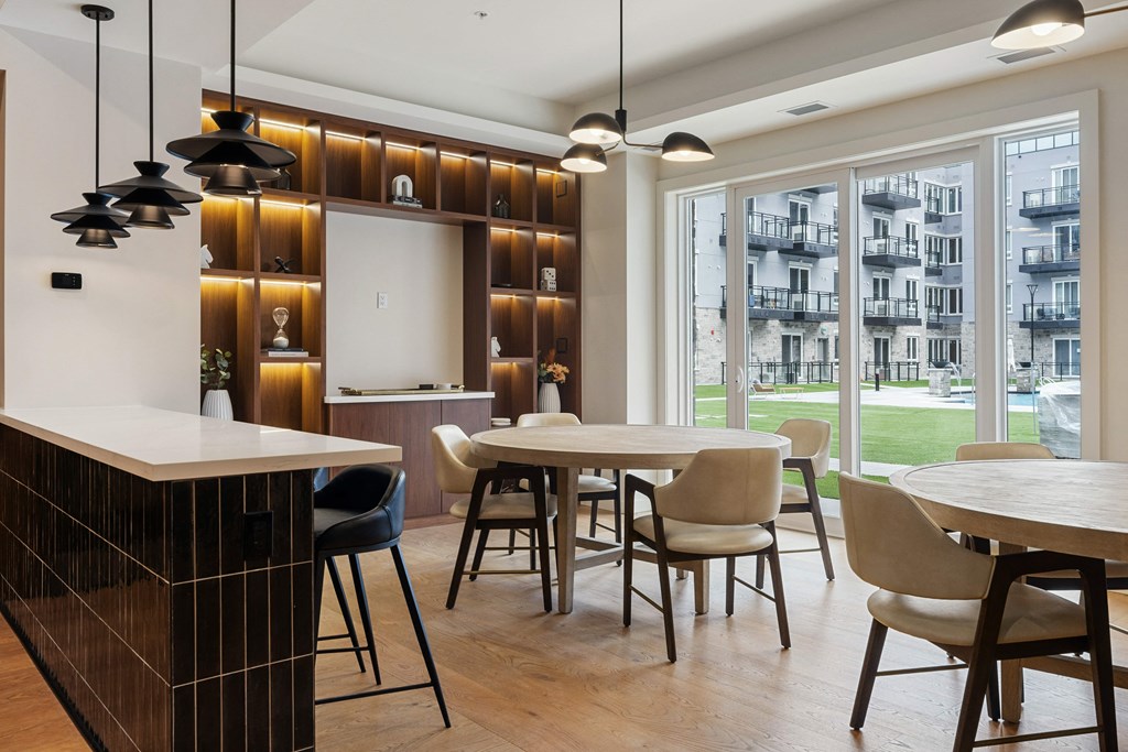a dining area with tables and chairs and a kitchen with large windows at 2274 Princess St., Kingston, ON