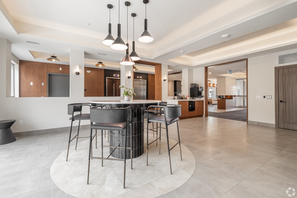 A modern kitchen with a bar area and a dining table.