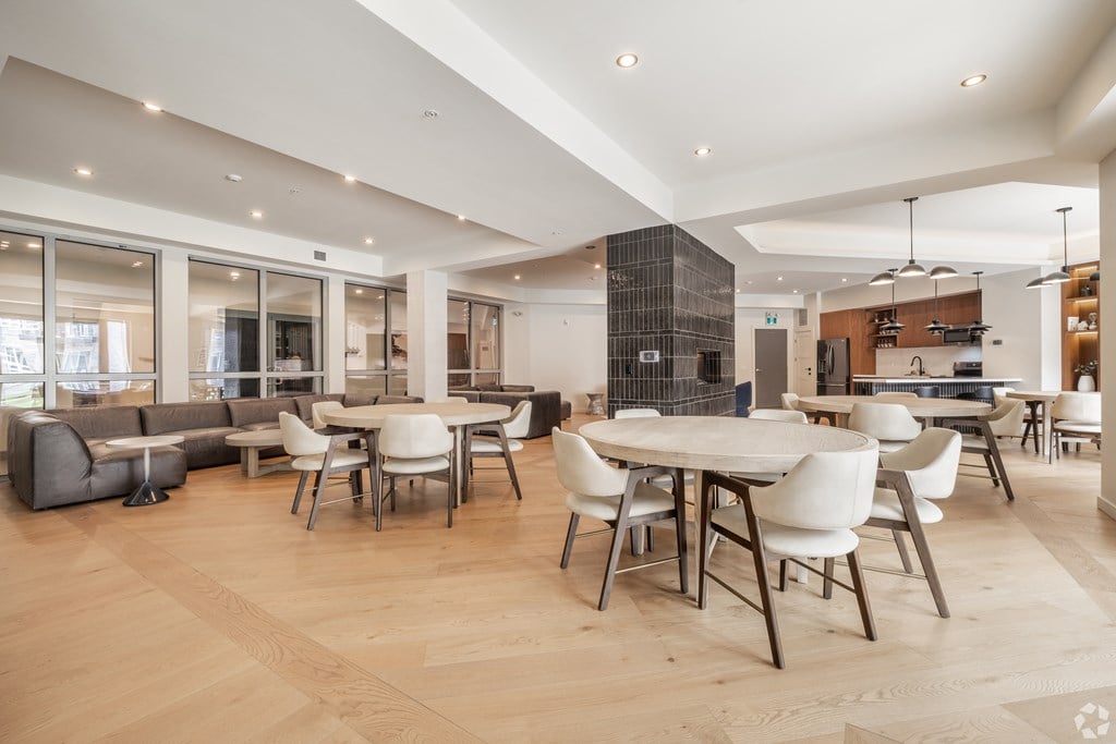 A modern dining room with a large table surrounded by chairs.