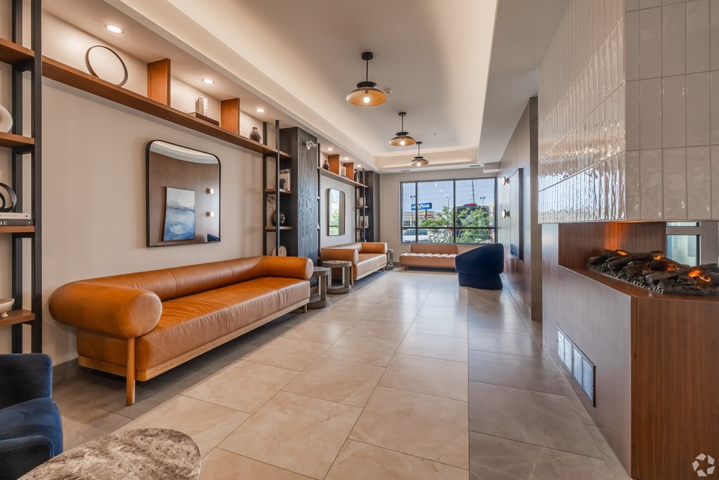 A modern living room with a long sofa and a fireplace.
