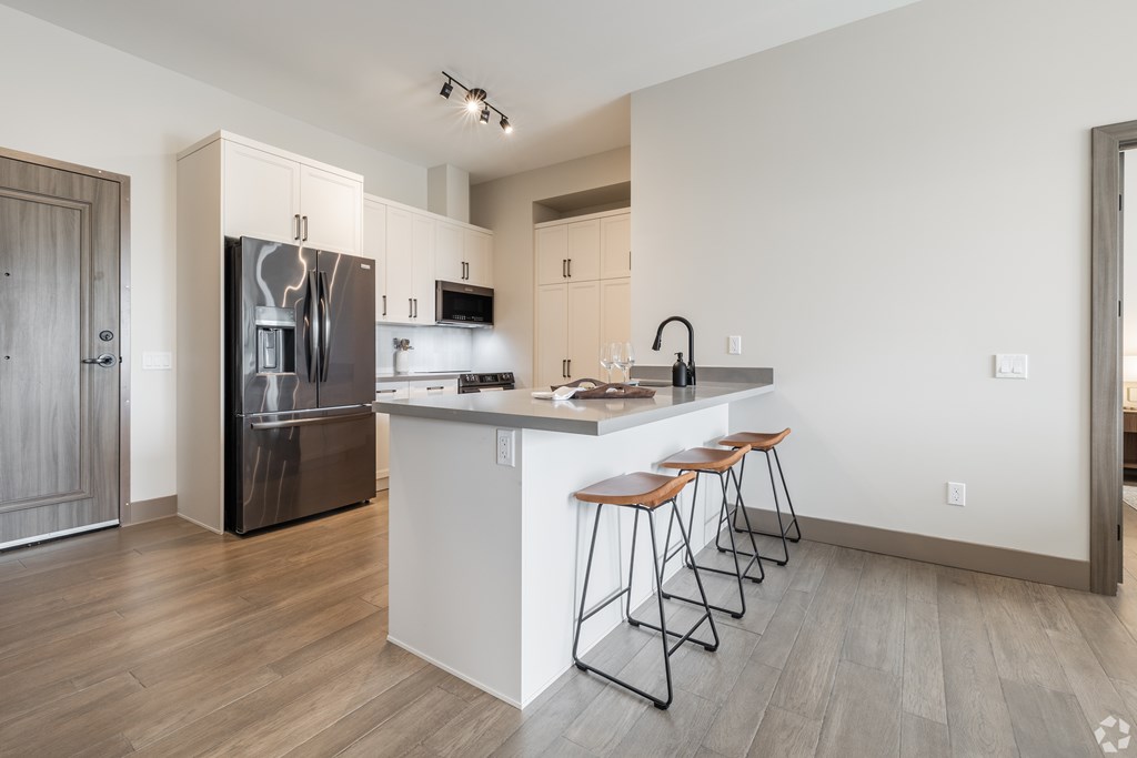 A kitchen with a white counter and a refrigerator.