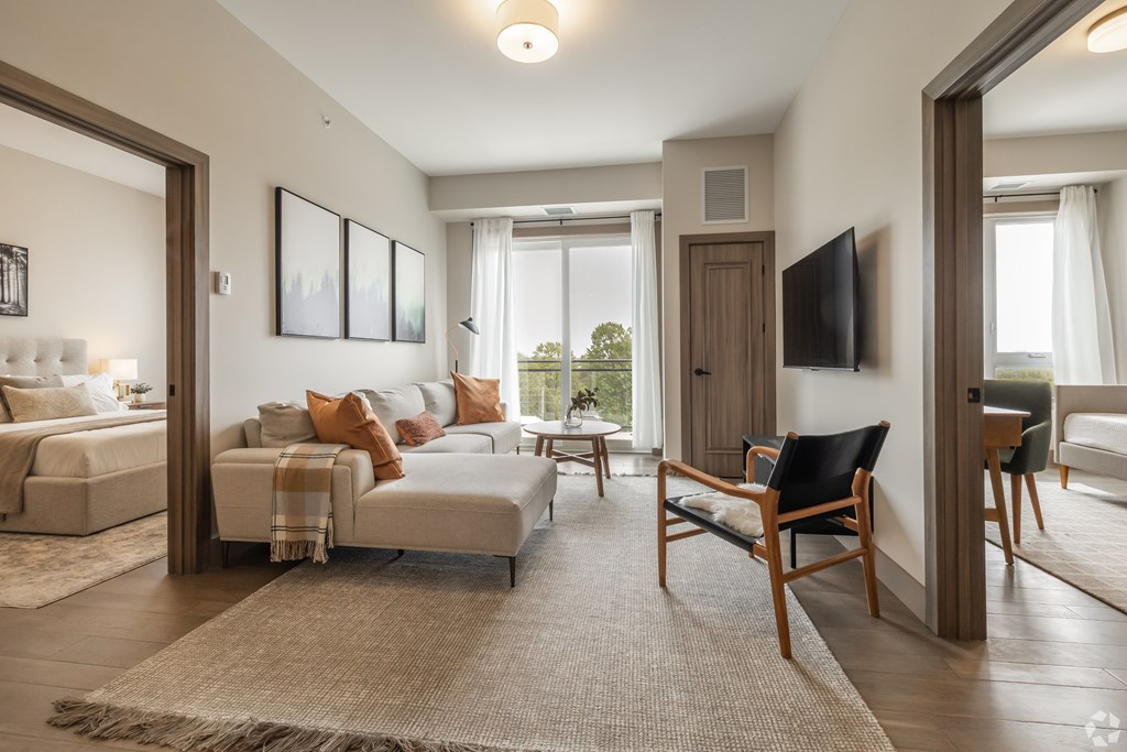 A living room with a white couch and a wooden chair.