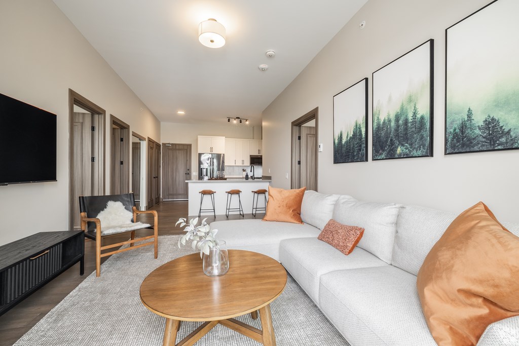 A living room with a white couch and a wooden coffee table.