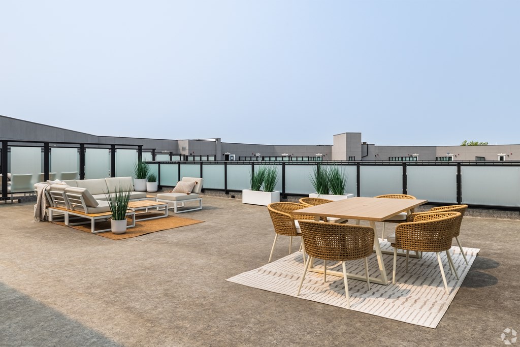 A patio with a table and chairs is set up on a rooftop.