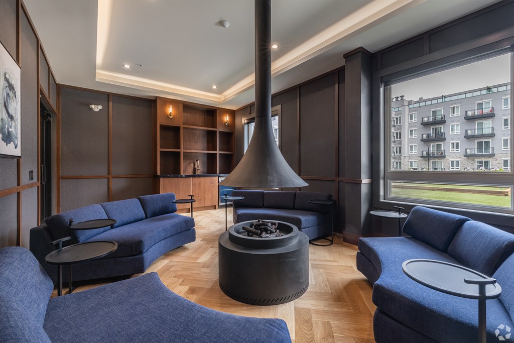 A modern living room with a fireplace and blue couches.