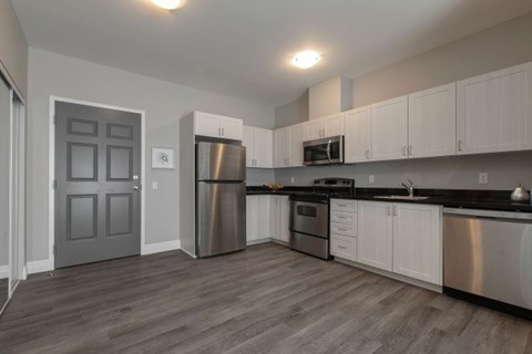A kitchen with a stainless steel refrigerator, oven, and microwave.