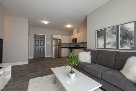 A modern living room with a grey couch and a white coffee table.