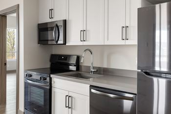 A modern kitchen with a black microwave above the stove