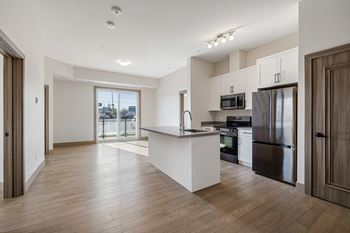 A kitchen with a refrigerator, oven, and microwave