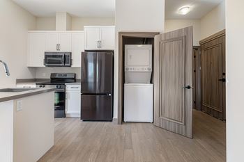 A kitchen with a black refrigerator, white dishwasher, and a black stove top