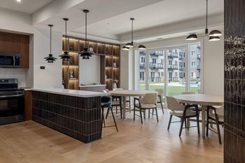 A modern kitchen with a large island and a dining table set up