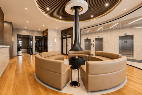 A modern living room with a large circular table and a fireplace.