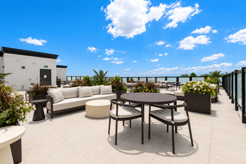 A patio with a table and chairs overlooking a body of water.