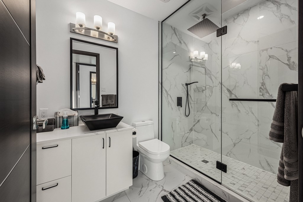 a bathroom with white cabinets and a black sink