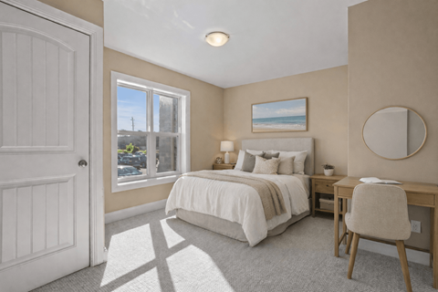 A bedroom with a bed, desk, and chair.