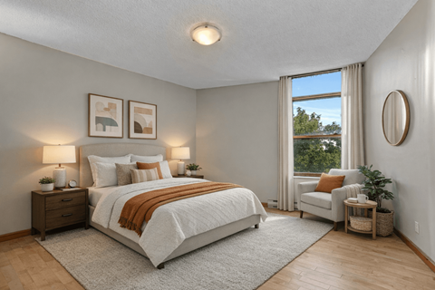 A bedroom with a large bed and a window with curtains.